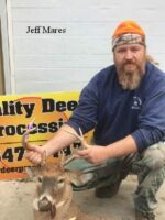 Man holding killed buck