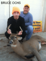 Man and boy holding killed buck